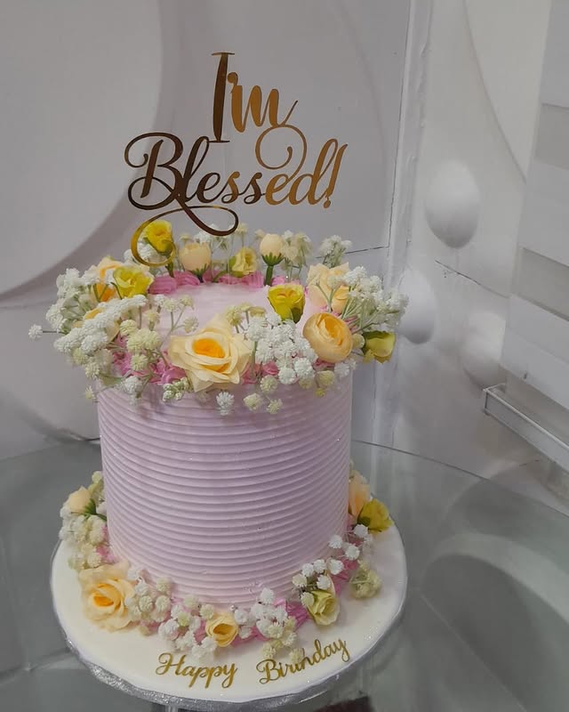 Pink ridged birthday cake with roses and a gold I'm Blessed! topper